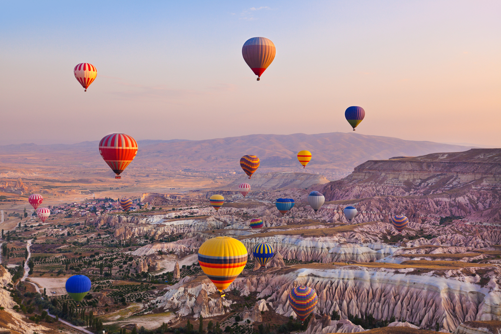 Hot air balloons flying above the volcanic valleys of Cappadocia