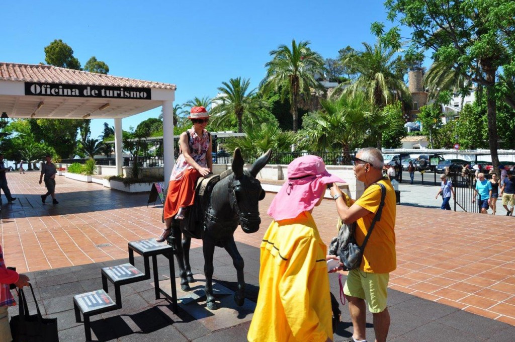 A holidaymaker posing for a photo on the donkey statue