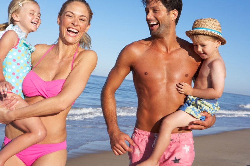 Family having fun on the beach while on holiday